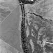 Oblique aerial view centred on the cropmarks of the round barrows, unenclosed settlement, souterrains, pits and rig at Auchenreoch, looking to the SE.