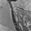 Oblique aerial view centred on the cropmarks of the round barrows, unenclosed settlement, souterrains, pits and rig at Auchenreoch, looking to the SE.