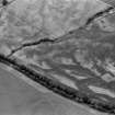 Oblique aerial view centred on the cropmarks of the round barrows, unenclosed settlement, souterrains, pits and rig at Auchenreoch, looking to the S.