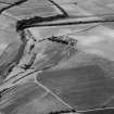 Oblique aerial view centred on the cropmarks of the enclosures and field system with the farmhouse and chapel adjacent at Chapeltown, looking to the NW.