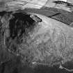 Oblique aerial view centred on the remains of the vitrified fort at Tap O' Noth, looking to the SE.