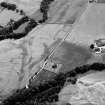 Oblique aerial view centred on the cropmarks of the Roman Temporary Camp, ring ditch and pits with Strathcathro Parish Church adjacent, looking to the SSW.