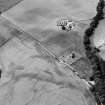 Oblique aerial view centred on the cropmarks of the Roman Temporary Camp, ring ditch and pits with Strathcathro Parish Church adjacent, looking to the W.
