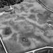 Oblique aerial view centred on the cropmarks of the unenclosed settlement, circular enclosure, ring ditch and pits at Monboddo, looking to the S.