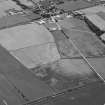 Oblique aerial view centred on the cropmarks of the circular enclosure, possible soutterain, field boundaries, pits and rig at Mains of Haulkerton with Laurencekirk adjacent, looking to the SE.