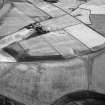 Oblique aerial view centred on the cropmarks of the unenclosed settlement, ring ditches, souterrains, enclosure, linear features, rig and pits at Newbarns, looking to the W.