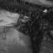 Oblique aerial view centred on the cropmarks of the unenclosed settlement, ring ditches, possible souterrain and pits with Glenbervie House and Policies adjacent at Glenbervie, looking to the SSE.
