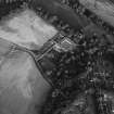 Oblique aerial view centred on the cropmarks of the unenclosed settlement, ring ditches, possible souterrain and pits with Glenbervie House and Policies adjacent at Glenbervie, looking to the SE.
