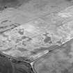 Oblique aerial view centred on the cropmarks of the square barrow, roundhouses, subrectangular buildings, ring ditch and pits at Kinchyle and Little Kildrummie, looking to the W.