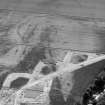 Oblique aerial view centred on the cropmarks of the enclosure and the former airfield at Brackla House, looking to the WSW.