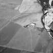 Oblique aerial view centred on the cropmarks of the ring ditch house and roundhouse at Blairnafade, looking to the NE.