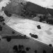 Oblique aerial view centred on the cropmarks of the ring ditches and rig at Kinnaird Park, looking to the NW.