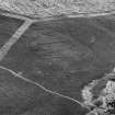 Oblique aerial view centred on the remains of a settlement, ring ditches and field system at Burn of Mannie, looking to to the ENE.