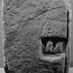 Photograph of fragment of sculptured stone bearing lower half of figure.