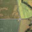 Eckford, oblique aerial view, taken from the E, centred on the cropmarks of an enclosure suurrounding a barrow and pit-circle.