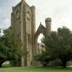 View of bell tower with clock and remains of tracery window from SW