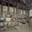 Interior. Retort House: View of retort benches 1 and 2 from NW with coal handling artefacts in foreground.