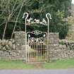 Detail of wrought iron gateway to garden on E side of road with crook and lambs overthrow, 'C H' monogram and naturalistic plant forms.