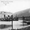 Scanned image of photograph showing pier head building including part of the pier and a small crane from ENE.
Titled 'Jetty at Loch Long'.