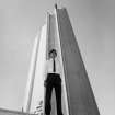 View of male guide standing in front of the British Pavilion tower at Expo 67.