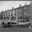 General view of St. James Terrace, Glasgow, with large group of children outside.
Titled below: ' 3 dwellings, 3 apartments, 24 dwellings, 1 apartment: 2 wash-houses containing in all 29 taps and 8 W.Cs '.