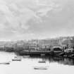 Scanned image of photograph showing a general view of Stromness piers and harbour from mid-way along the town shore, taken from the N and looking S to Hoy.
