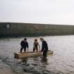 'Loch Doon' logboat experimental reconstruction (at Scottish Fisheries Museum, Anstruther): spring 1992. Launch day: logboat in water.
