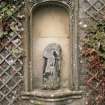 Detail of niche, with remains of sculptured figure, set into wall of formal garden.