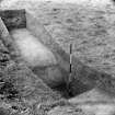 Digital copy of excavation photograph: unidentified trench across earthworks.