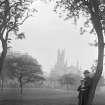 View of gentleman and boy leaning on tree with a distant view of Holy Trinity Church