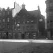 View of front elevation of 15 - 19 the Grassmarket, part of 21 (Thos Munro & Son), the corner of the Women's Hostel (Salvation Army), and the entrance to the Vennel