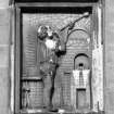 Edinburgh, 73-91 Holyrood Road.
Detail of panel showing figure working.