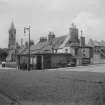 General view of the buildings on the corner of Summerhall Square and Summerhall (demolished in 1913) on the site of the Royal (Dick) Veterinary College, with the church in the background seen from the South West.