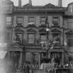 View from south of the bank festooned with flowers and two crowns above each door made of flowers with people outside and horse and cart, possibly for the coronation of Edward VII or George V.