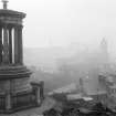 View of monument with view of Edinburgh behind, covered in fog