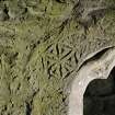 Detail of incised carving over window at E end in S wall.
