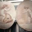 Painted oval panels: cherub on sea-creature and cherubs scything.