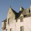 Detail of corner turret, crow-step gable and dormer windows at West end of South facade.