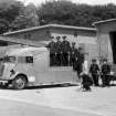 View Fire engine with trailer and firemen at fire station.