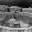 View of a man working with the boiling vats, unloading stabilised guncotton at Bishopton Royal Ordnance Factory, Renfrewshire.