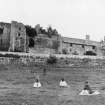 General view of South elevation of Aberdour Castle with people in foreground.