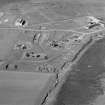 Oblique aerial view of Orkney, Hoy, Lyness, Royal Naval Oil Terminal, view from S, of the site of the torpedo depot with a group of air raid shelters, generator house and several ancillery buildings. Part of the former recreation centre, NAAFI are in the background.