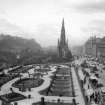 General view of Princes Street, Edinburgh, looking westwards showing the Castle, Mound, Scott Monument, Waverley Gardens and a busy street with trams, pedestrians and horse drawn buses and carriages.