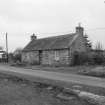 Scanned image of view of unidentified cottage in village.