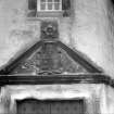 Detail of pediment with armorial panel above entrance doorway of corner tower.