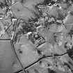 Oblique aerial view centred on the church, burial ground, manse and farmstead with smithy adjacent, taken from the SW.