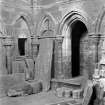 Historic photograph showing detail of tombstones and stone sculpture in sacristy.