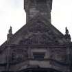 View of carved Royal Arms of Scotland and two shields on central chimney gable, E side of building (North Bridge).