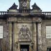 View of entrance to courtyard of Palace, showing crowned cupola, reclining female figures and dolphins; a frieze on which are metopes carved with the cypher of Charles II; and the Royal Arms of Scotland.