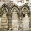 View of two carved medallion heads, between ground floor arches on W facade of Holyrood Abbey.